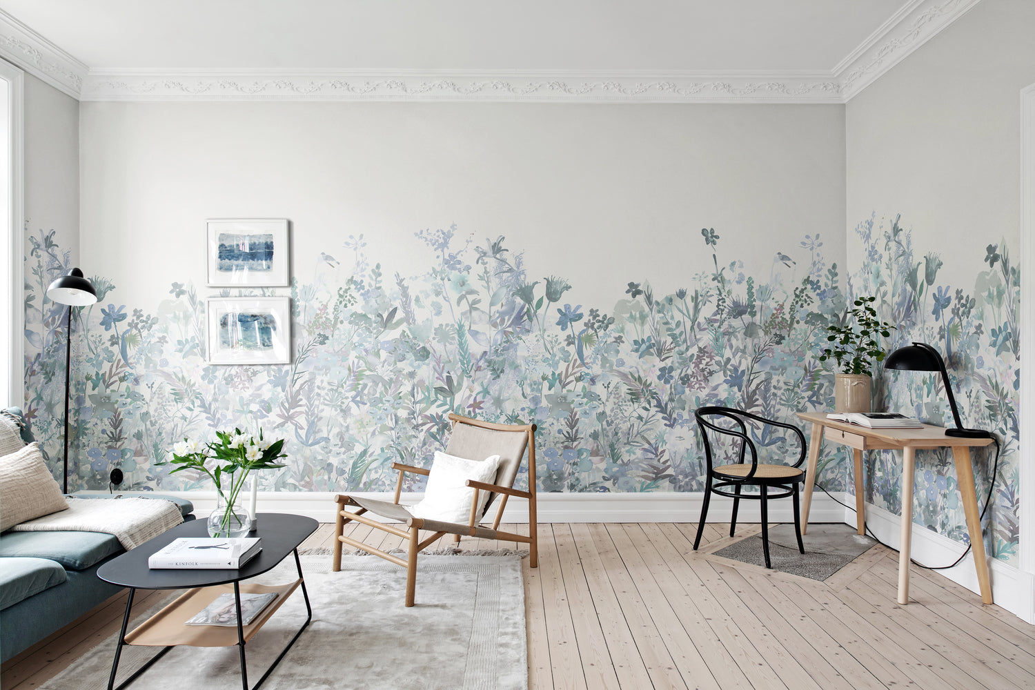 Wildflower mural wallpaper in soft blue in a living room with light wooden furniture and study table