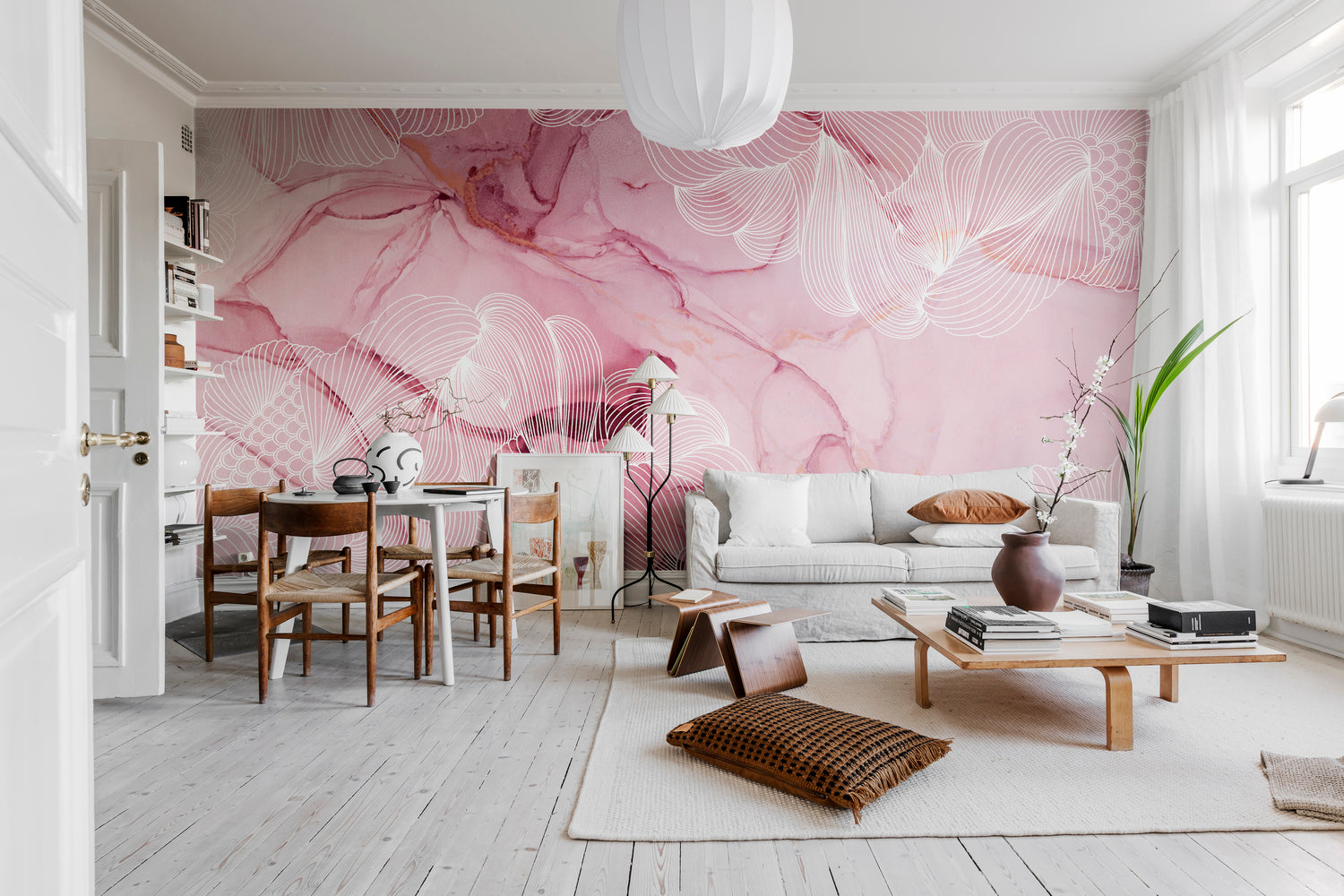 Pink living room wallpaper mural with expressive floral artwork creating a bold feature wall