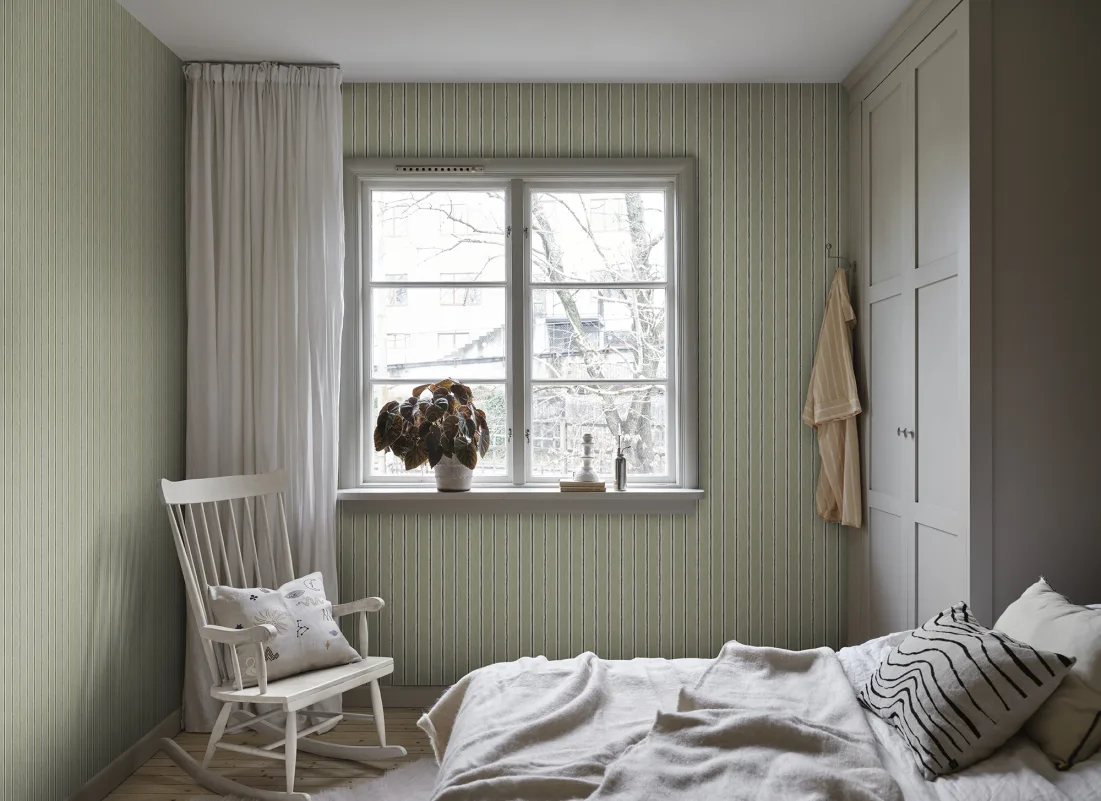 Albin Striped Wallpaper in Dark Green installed in a bedroom with green cabinetry and wooden accents