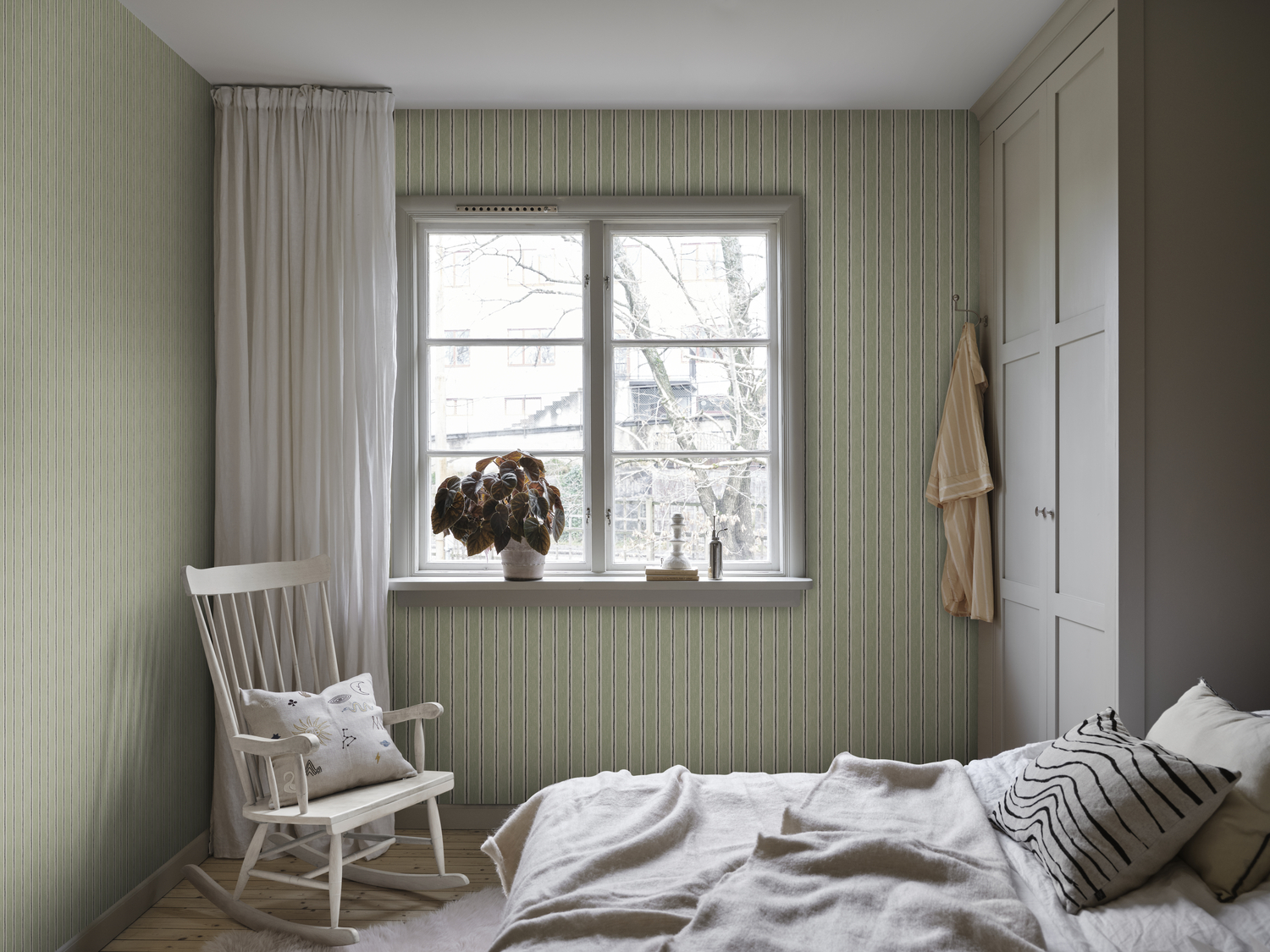 green striped wallpaper with hand-drawn design featured in cosy bedroom