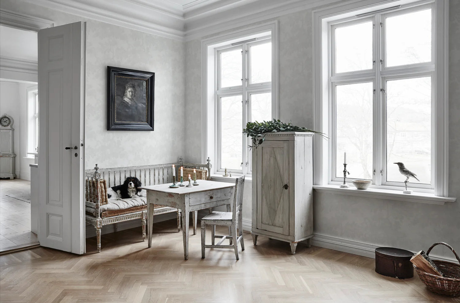 Raphael Floral, Wallpaper in White featured on a wall of a living area with white wooden furnitures and a herringbone wooden flooring