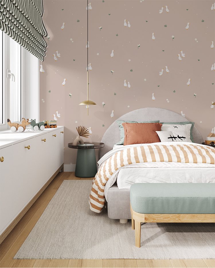 Soft blush pink wallpaper in a toddler room with pendant lights and white cabinets