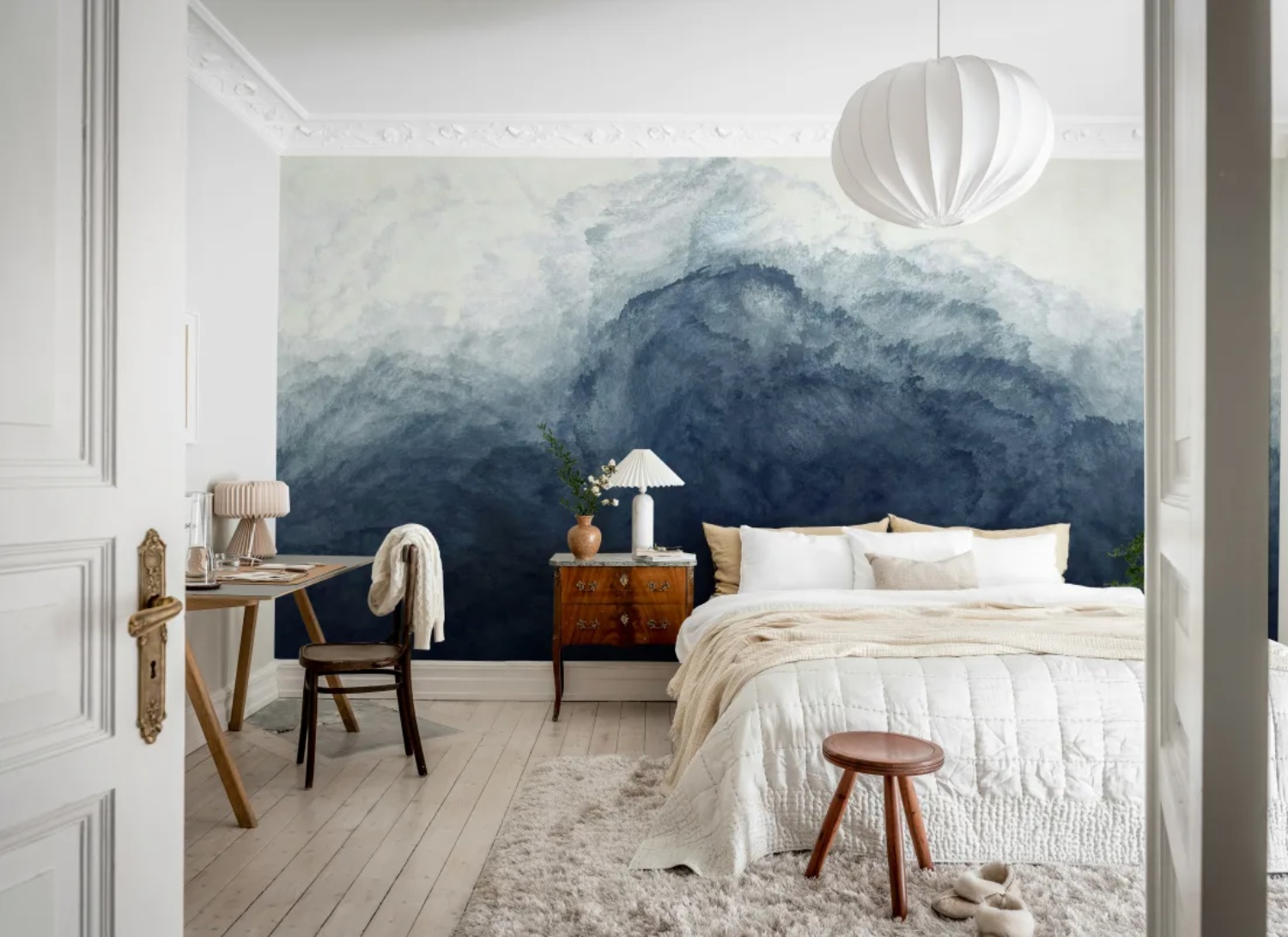 abstract watercolour blue ombre wallpaper mural in bedroom with white bed and wooden furnishing
